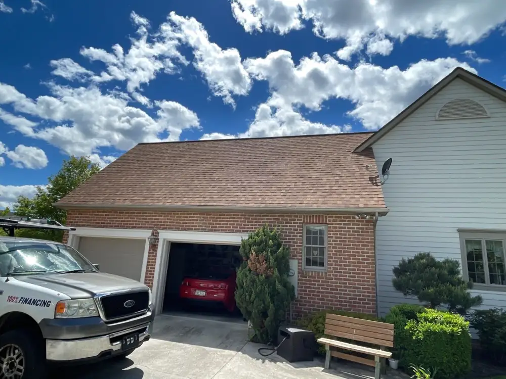 A brick house with a two-car garage and a new brown roof