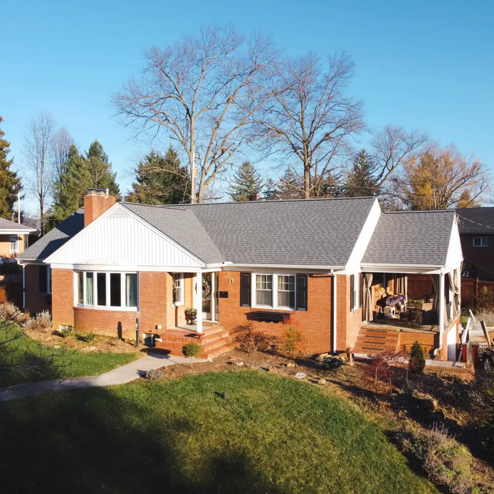 A brick rancher with a white gable and a new grey roof