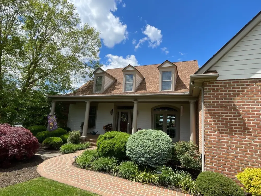 Joe's brick house with its new brown roof and three dormers